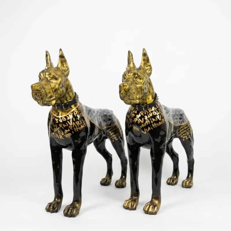 Zwei Dobermann-Skulpturen in Schwarz und Gold nebeneinander