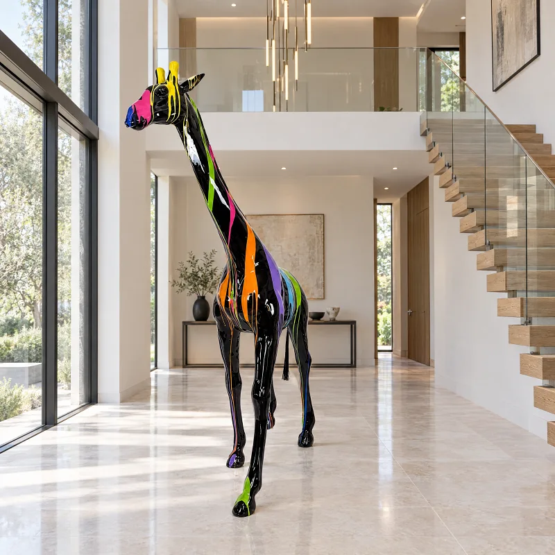 Schwarze Giraffen-Skulptur mit Farbläufen in einem hohen, hellen Eingangsbereich