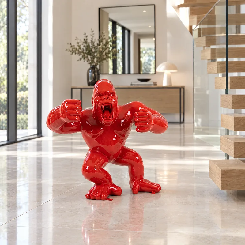 Rote Gorilla-Skulptur in Hochglanz neben einer Holztreppe mit Glasgeländer